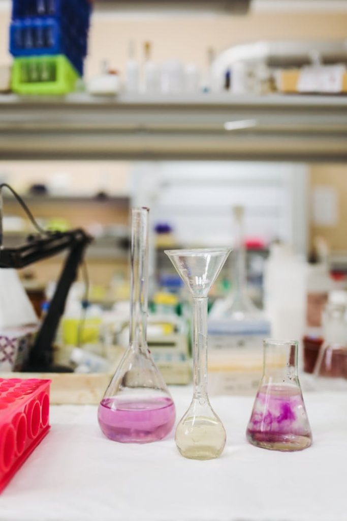 Various chemicals in beakers with vibrant hues in a modern lab setting.